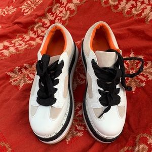 Beautiful white beige with black laces sports tennis shoes very fancy.